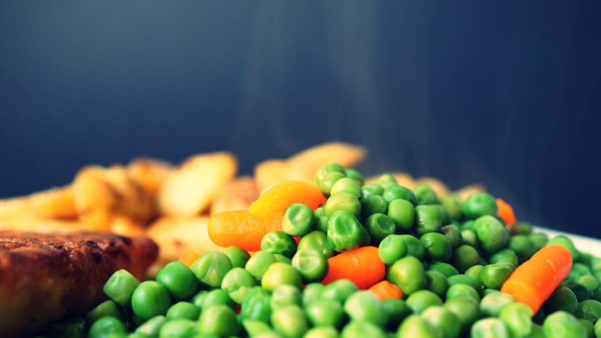 Fresh peas and carrots plated, creating a colorful and healthy meal option.